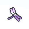 NerdyKeppie's BONEYARD Dragonfly Embroidered Pride Patch are shaped like their namesake and stitched on black duck cloth!