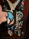 A person wearing a NerdyKeppie BONEYARD Trans Pride Stencil Roses Pride Tank Swimsuit Without Skirt - 2X. A pair of joggers with two deep pockets, its Neon Tarot pattern is in non-binary or genderfluid flag colors. These pride jogger sweatpants have a relaxed fit in the waist, hips, and thighs.
