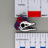 NerdyKeppie Proud to the Bone Archaeopteryx Skull Pride Enamel Pins. An archaeopteryx skull pride enamel pin for our Proud to the Bone project. This prehistoric pin is wearing an adorable crown of flowers!