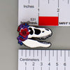 NerdyKeppie Proud to the Bone Tyrannosaurus Rex Skull Pride Enamel Pins. A Tyrannosaurus Rex skull pride enamel pin for our Proud to the Bone project. This prehistoric T-Rex pin is wearing an adorable crown of flowers!