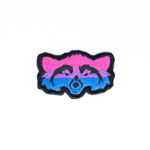 NerdyKeppie's Bi Raccoon Embroidered Pride Patch are shaped like their namesake and stitched on black duck cloth!