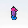 NerdyKeppie's Bi Seahorse Embroidered Pride Patch are shaped like their namesake and stitched on black duck cloth!