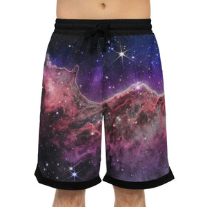 A person wearing a NerdyKeppie Carina Nebula Bi Pride Basketball Shorts with Pockets. A pair of basketball shorts featuring a bisexual Carina Nebula pattern. These bi pride basketball shorts fall just above the knee and have big pockets.