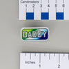 NerdyKeppie "DADDY" Mirrored Pride Pin. Mirrored pride pin with "DADDY" text in your choice of bear, gay men's / MLM, rainbow, or transgender pride colors. Say it with your whole chest.