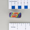 NerdyKeppie "DYKE" Mirrored Pride Pin. Mirrored pride pin with "DYKE" text, available in lesbian, Progress, or rainbow pride colors. Say it with your whole chest.