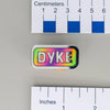 NerdyKeppie "DYKE" Mirrored Pride Pin. Mirrored pride pin with "DYKE" text, available in lesbian, Progress, or rainbow pride colors. Say it with your whole chest.