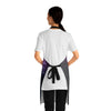 A person wearing a NerdyKeppie Galaxy Bi Pride Apron With Pocket. A black apron with a galaxy design on it in bisexual pride colors. This bi pride pocket apron is made of durable 100% polyester.