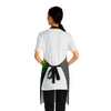 A person wearing a NerdyKeppie Galaxy Rainbow Gay Pride Apron With Pocket. A black apron with a galaxy design on it in rainbow gay pride colors. This rainbow gay pride pocket apron is made of durable 100% polyester.