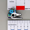 NerdyKeppie Proud to the Bone Archaeopteryx Skull Pride Enamel Pins. An archaeopteryx skull pride enamel pin for our Proud to the Bone project. This prehistoric pin is wearing an adorable crown of flowers!