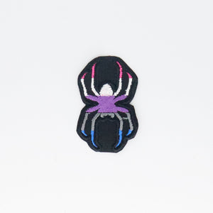 NerdyKeppie's Genderfluid Spider Embroidered Pride Patch are shaped like their namesake and stitched on black duck cloth!