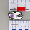 NerdyKeppie Proud to the Bone Cave Bear Skull Pride Enamel Pins. A Cave Bear skull pride enamel pin for our Proud to the Bone project. This prehistoric pin is wearing an adorable crown of flowers!