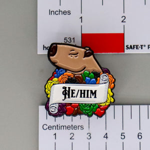 NerdyKeppie Capybara Enamel More Color More Pride Pronoun Pins. Our enamel pin features an adorable capybara, a paper scroll with three different pronoun choices, and flowers in More Color More Pride colors. This pride pin ships from Portland, Oregon.