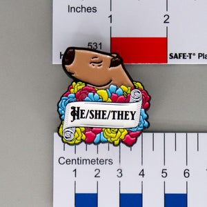 NerdyKeppie Capybara Enamel Pan Pride Pronoun Pins. Our enamel pin features an adorable capybara, a paper scroll with six different pronoun choices, and flowers in pansexual pride colors. This pride pin ships from Portland, Oregon.