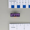 NerdyKeppie "Lavender Menace" Enamel Pin. A black metal pin with lavender stencil text on it reading LAVENDER MENACE. Perfect for queers who scare cishet feminists?