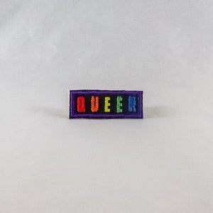 NerdyKeppie's No Hooked Backing "QUEER" Embroidered Rainbow Gay Pride Patches are stitched on sturdy rectangular duck cloth and backed with vinyl fuse.