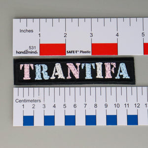 NerdyKeppie's No Hooked Backing "TRANTIFA" Embroidered Anti-Fascist Trans Pride Patch are stitched on sturdy rectangular duck cloth and backed with vinyl fuse.
