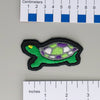 NerdyKeppie's Painted Turtle Embroidered Pride Patch are shaped like their namesake and stitched on black duck cloth!