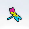 NerdyKeppie's Pan Dragonfly Embroidered Pride Patch are shaped like their namesake and stitched on black duck cloth!