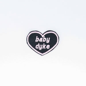 NerdyKeppie's Pink "Baby Dyke" Heart Embroidered Pride Patch are stitched on black duck cloth and backed by sturdy vinyl fuse.