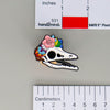 NerdyKeppie Proud to the Bone Archaeopteryx Skull Pride Enamel Pins. A Archaeopteryx skull pride enamel pin for our Proud to the Bone project. This prehistoric pin is wearing an adorable crown of flowers!