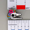 NerdyKeppie Proud to the Bone Archaeopteryx Skull Pride Enamel Pins. An archaeopteryx skull pride enamel pin for our Proud to the Bone project. This prehistoric pin is wearing an adorable crown of flowers!