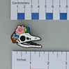 NerdyKeppie Proud to the Bone Archaeopteryx Skull Pride Enamel Pins. An archaeopteryx skull pride enamel pin for our Proud to the Bone project. This prehistoric pin is wearing an adorable crown of flowers!