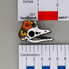 NerdyKeppie Proud to the Bone Archaeopteryx Skull Pride Enamel Pins. An archaeopteryx skull pride enamel pin for our Proud to the Bone project. This prehistoric pin is wearing an adorable crown of flowers!