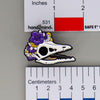 NerdyKeppie Proud to the Bone Archaeopteryx Skull Pride Enamel Pins. An archaeopteryx skull pride enamel pin for our Proud to the Bone project. This prehistoric pin is wearing an adorable crown of flowers!