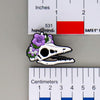 NerdyKeppie Proud to the Bone Archaeopteryx Skull Pride Enamel Pins. An archaeopteryx skull pride enamel pin for our Proud to the Bone project. This prehistoric pin is wearing an adorable crown of flowers!