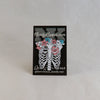 NerdyKeppie Proud to the Bone Human Ribcage Pride Enamel Pins. A human ribcage pride enamel pin for our Proud to the Bone project, wearing an adorable crown of flowers!