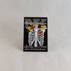 NerdyKeppie Proud to the Bone Human Ribcage Pride Enamel Pins. A human ribcage pride enamel pin for our Proud to the Bone project, wearing an adorable crown of flowers!