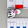 NerdyKeppie Proud to the Bone Triceratops Skull Pride Enamel Pins. A Triceratops skull pride enamel pin for our Proud to the Bone project. This prehistoric pin is wearing an adorable crown of flowers!