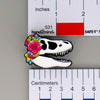 NerdyKeppie Proud to the Bone Tyrannosaurus Rex Skull Pride Enamel Pins. A Tyrannosaurus Rex skull pride enamel pin for our Proud to the Bone project. This prehistoric T-Rex pin is wearing an adorable crown of flowers!