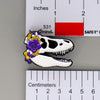 NerdyKeppie Proud to the Bone Tyrannosaurus Rex Skull Pride Enamel Pins. A Tyrannosaurus Rex skull pride enamel pin for our Proud to the Bone project. This prehistoric T-Rex pin is wearing an adorable crown of flowers!