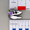 NerdyKeppie Proud to the Bone Tyrannosaurus Rex Skull Pride Enamel Pins. A Tyrannosaurus Rex skull pride enamel pin for our Proud to the Bone project. This prehistoric T-Rex pin is wearing an adorable crown of flowers!