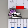 NerdyKeppie Proud to the Bone Archaeopteryx Skull Pride Enamel Pins. An archaeopteryx skull pride enamel pin for our Proud to the Bone project. This prehistoric pin is wearing an adorable crown of flowers!