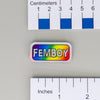 NerdyKeppie "FEMBOY" Mirrored Pride Pin. Mirrored pride pin with "FEMBOY" text, available in genderfluid, non-binary, rainbow, or transgender pride. Say it with your whole chest.