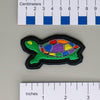 NerdyKeppie's Rainbow Painted Turtle Embroidered Pride Patch are shaped like their namesake and stitched on black duck cloth!