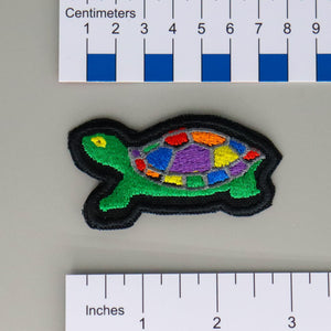NerdyKeppie's Rainbow Painted Turtle Embroidered Pride Patch are shaped like their namesake and stitched on black duck cloth!