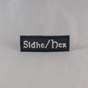 NerdyKeppie's "Sidhe/Her" Embroidered Pronoun Patches are stitched on sturdy rectangular duck cloth and backed with vinyl fuse.