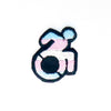NerdyKeppie's Trans Disability Symbol Embroidered Pride Patch are shaped like their namesake and stitched on black duck cloth!