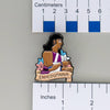 NerdyKeppie Enheduanna Historically Queer Enamel Pride Pin. Our NerdyKeppie Historically Queer Pride enamel pin features Enheduanna surrounded by flowers in your choice of transgender, non-binary, or Spirit of '77 pride colors. This pride pin ships from Portland, Oregon.