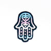 NerdyKeppie's Trans Hamsa Embroidered Pride Patch are stitched on black duck cloth and backed by sturdy vinyl fuse.