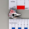 NerdyKeppie Proud to the Bone Archaeopteryx Skull Pride Enamel Pins. An archaeopteryx skull pride enamel pin for our Proud to the Bone project. This prehistoric pin is wearing an adorable crown of flowers!
