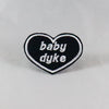 NerdyKeppie's White BONEYARD "Baby Dyke" Heart Embroidered Pride Patch are stitched on black duck cloth and backed by sturdy vinyl fuse.
