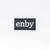 NerdyKeppie's White "Enby" Embroidered Non-Binary Pride Patch are stitched on sturdy rectangular duck cloth and backed with vinyl fuse.