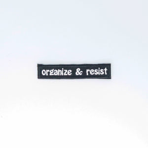 NerdyKeppie's White "Organize and Resist" Embroidered Patch are stitched on sturdy rectangular duck cloth and backed with vinyl fuse.