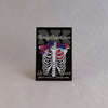 NerdyKeppie Proud to the Bone Human Ribcage Pride Enamel Pins. A human ribcage pride enamel pin for our Proud to the Bone project, wearing an adorable crown of flowers!